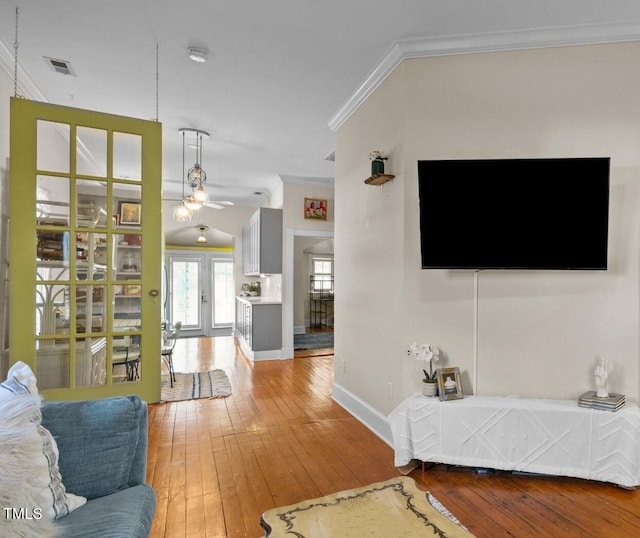 living room with hardwood / wood-style floors, french doors, ceiling fan, and ornamental molding