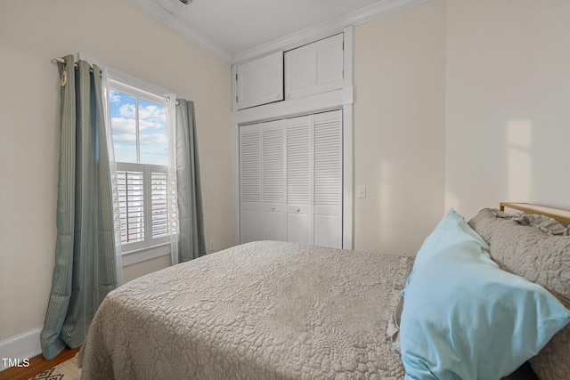 bedroom featuring a closet, wood-type flooring, and ornamental molding