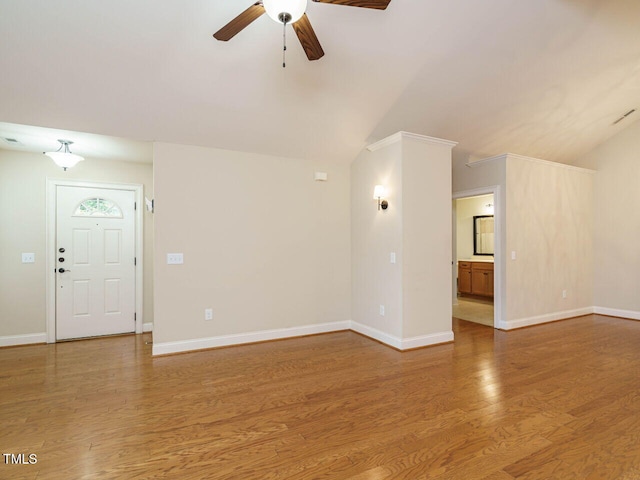 unfurnished living room featuring hardwood / wood-style flooring, ceiling fan, ornamental molding, and vaulted ceiling