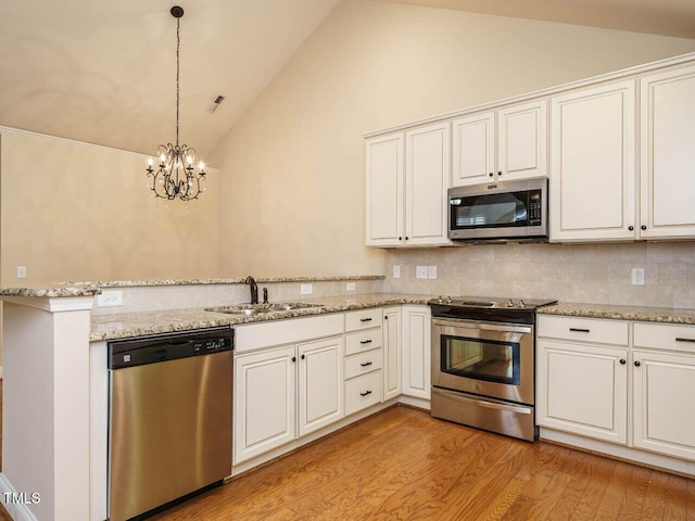 kitchen with high vaulted ceiling, an inviting chandelier, sink, decorative backsplash, and appliances with stainless steel finishes