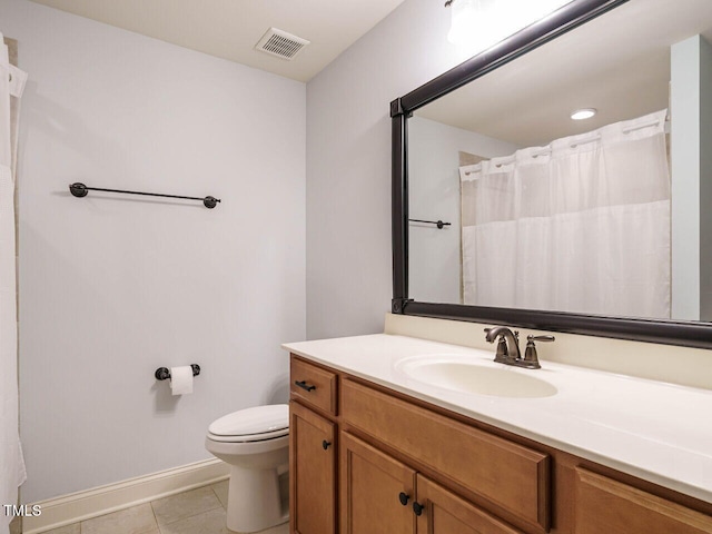 bathroom with tile patterned flooring, vanity, and toilet