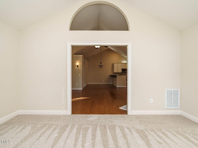 spare room with dark carpet, ceiling fan, and lofted ceiling