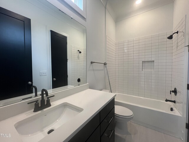 full bathroom featuring toilet, tiled shower / bath, and vanity