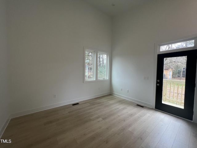 foyer entrance featuring a high ceiling and light wood-type flooring