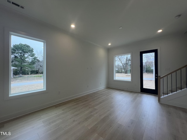 unfurnished room featuring light wood-type flooring and a wealth of natural light