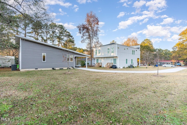 back of house with a lawn and a carport