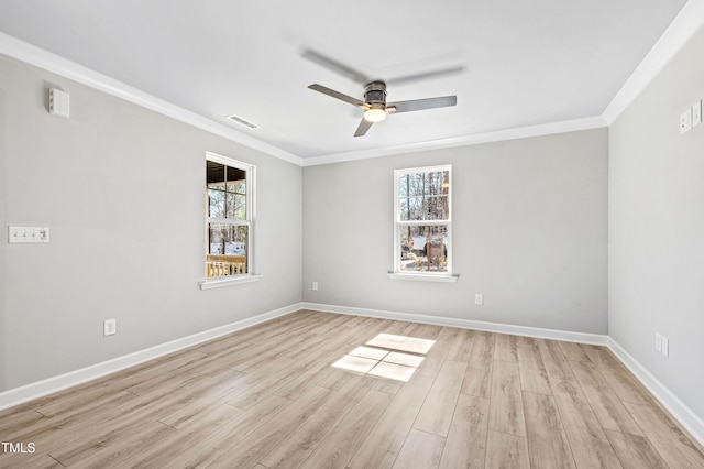 empty room featuring light wood finished floors, baseboards, and crown molding