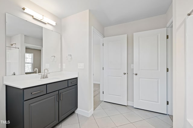 bathroom featuring walk in shower, tile patterned flooring, vanity, and baseboards