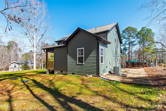 view of side of property featuring central AC, a yard, and crawl space