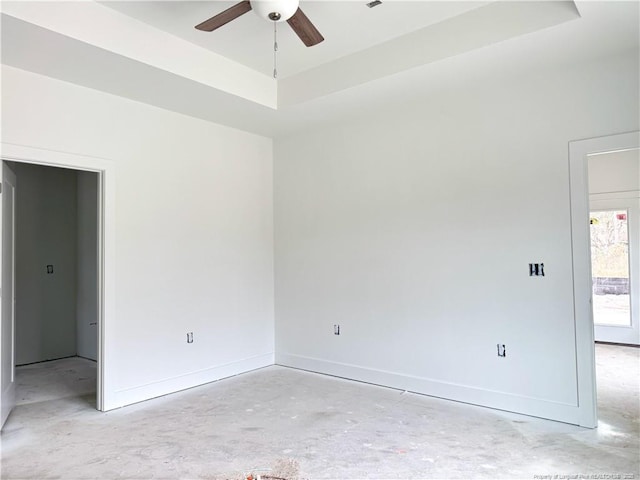 unfurnished room with baseboards, unfinished concrete flooring, and ceiling fan