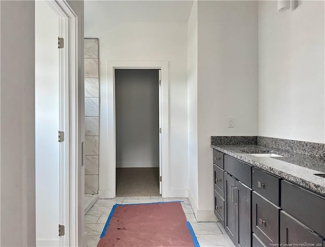 full bath featuring baseboards, marble finish floor, a sink, and a shower stall