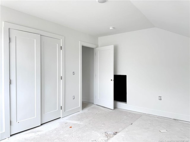 unfurnished bedroom featuring baseboards and vaulted ceiling