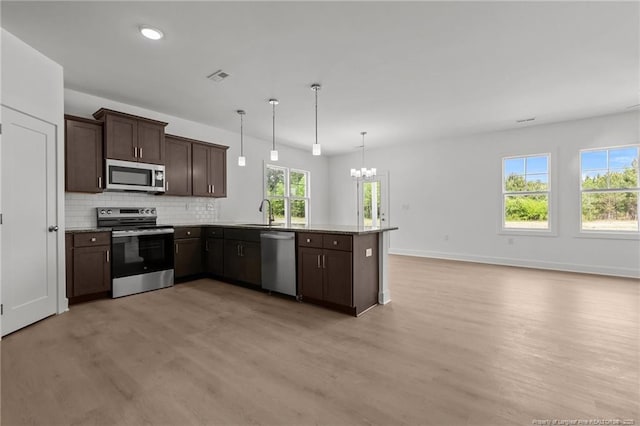 1585 Scull Rd, Raeford, NC 28376 - kitchen with appliances with stainless steel finishes, a chandelier, light wood finished floors, dark brown cabinets, and recessed lighting