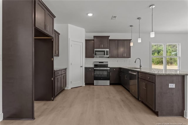 1585 Scull Rd, Raeford, NC 28376 - kitchen with appliances with stainless steel finishes, a sink, light wood finished floors, dark brown cabinetry, and a peninsula