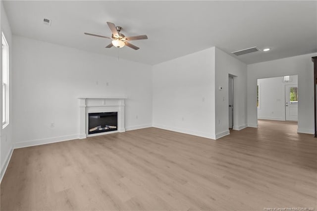 1585 Scull Rd, Raeford, NC 28376 - unfurnished living room with ceiling fan, light wood finished floors, baseboards, and a glass covered fireplace