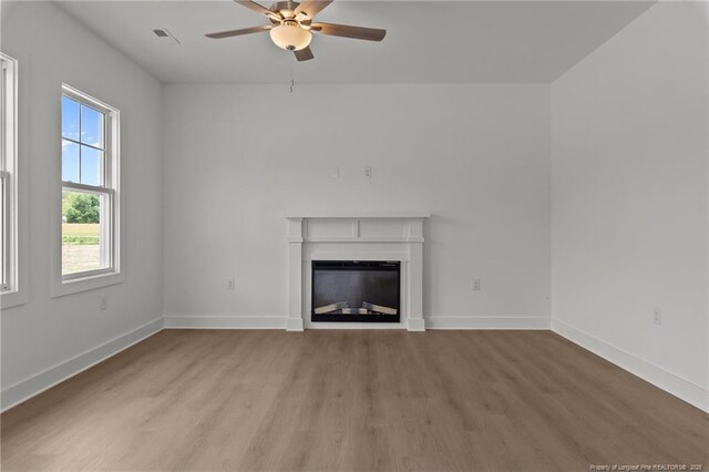 1585 Scull Rd, Raeford, NC 28376 - unfurnished living room featuring light wood-style floors, a ceiling fan, a fireplace, and baseboards