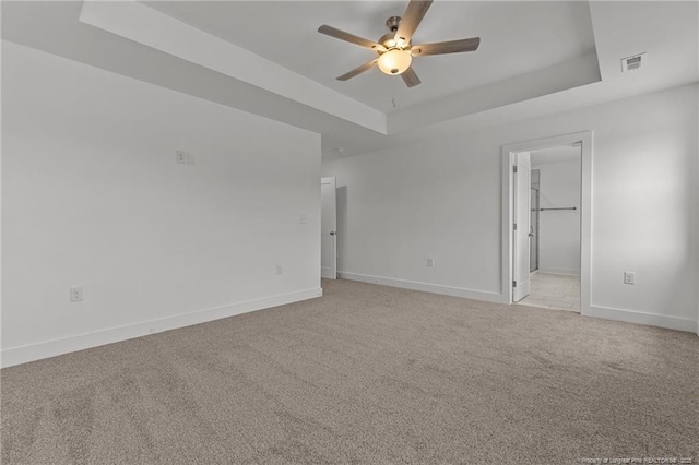 1585 Scull Rd, Raeford, NC 28376 - spare room with a raised ceiling, a ceiling fan, light colored carpet, and baseboards
