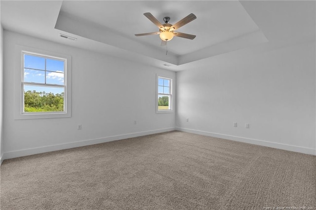1585 Scull Rd, Raeford, NC 28376 - spare room featuring a tray ceiling, baseboards, ceiling fan, and carpet