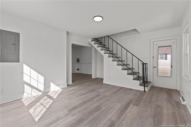 foyer with light hardwood / wood-style floors and electric panel