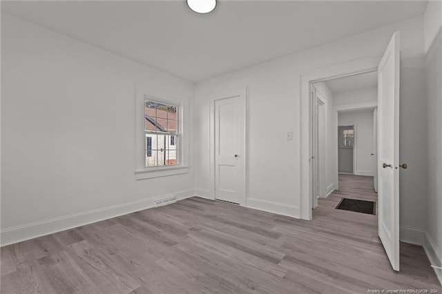 unfurnished bedroom featuring light wood-type flooring and a closet