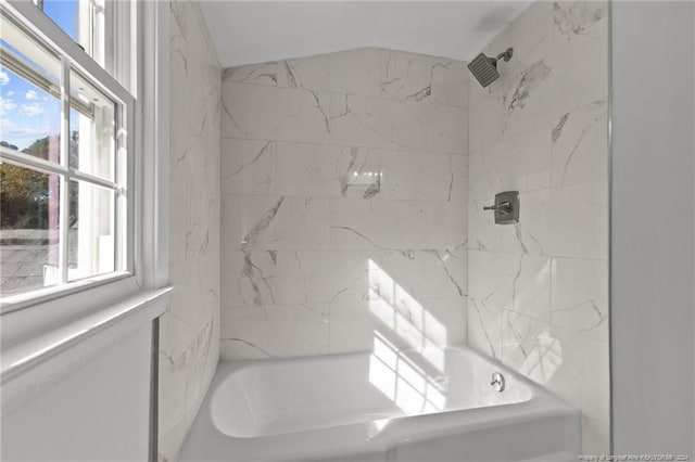 bathroom with tiled shower / bath combo and a healthy amount of sunlight