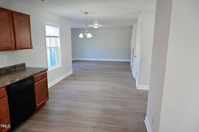 kitchen featuring dishwasher, decorative light fixtures, an inviting chandelier, and light hardwood / wood-style floors