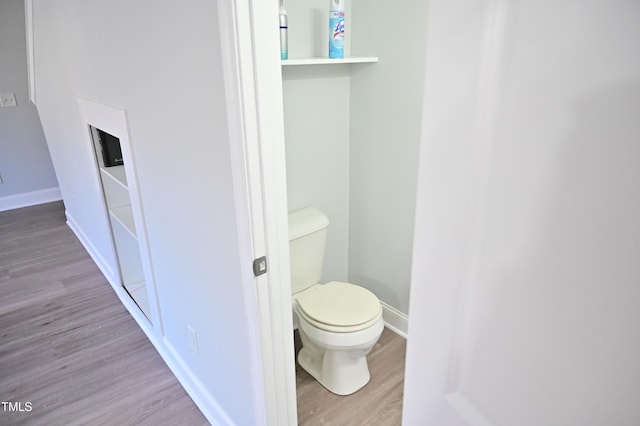 bathroom featuring hardwood / wood-style flooring and toilet