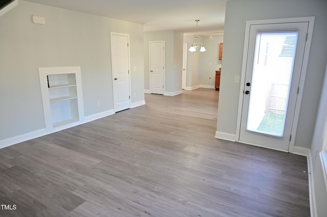 spare room with a chandelier and hardwood / wood-style floors