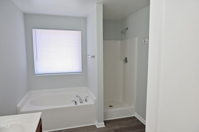 bathroom featuring vanity, wood-type flooring, and shower with separate bathtub