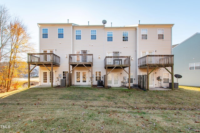 back of property featuring french doors, central AC, and a lawn