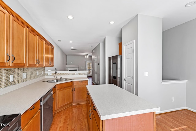 kitchen featuring stainless steel appliances, a kitchen island, light hardwood / wood-style floors, and sink