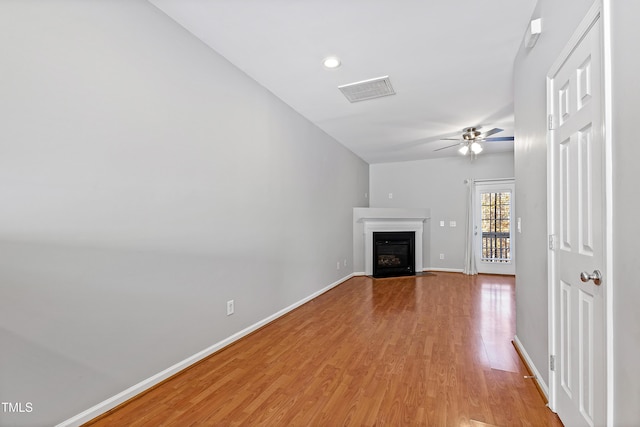 unfurnished living room with ceiling fan, light hardwood / wood-style floors, and lofted ceiling