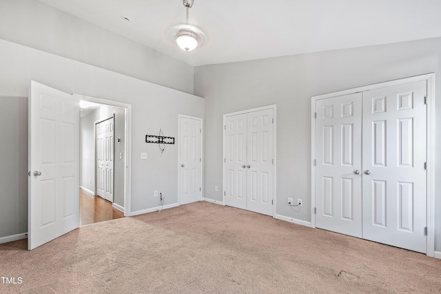 unfurnished bedroom featuring light carpet and lofted ceiling