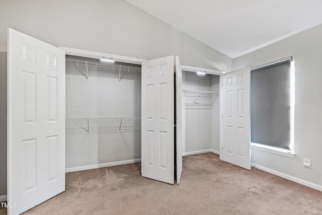 interior space featuring light carpet and vaulted ceiling