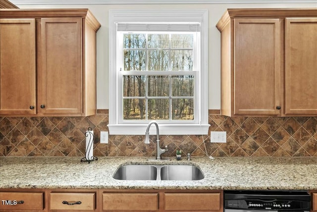 kitchen with sink, dishwashing machine, light stone countertops, and decorative backsplash