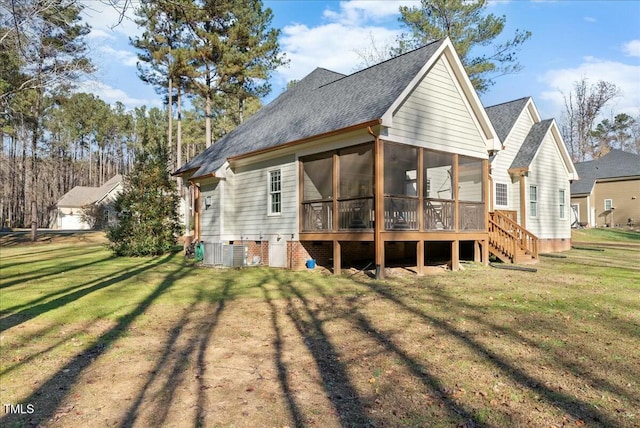 rear view of property featuring a sunroom, a yard, and central AC unit