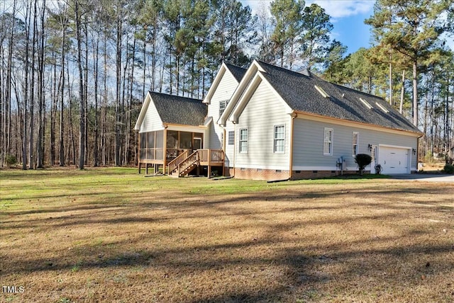 rear view of property featuring a garage, a sunroom, and a yard