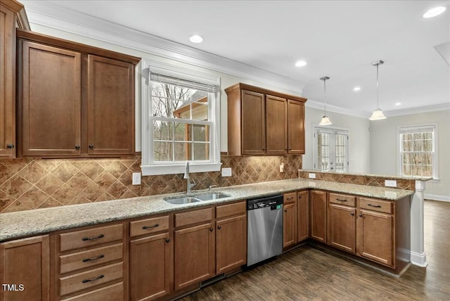 kitchen featuring dishwasher, sink, kitchen peninsula, pendant lighting, and dark wood-type flooring