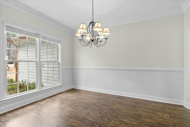 empty room with ornamental molding, a chandelier, a wealth of natural light, and dark hardwood / wood-style flooring