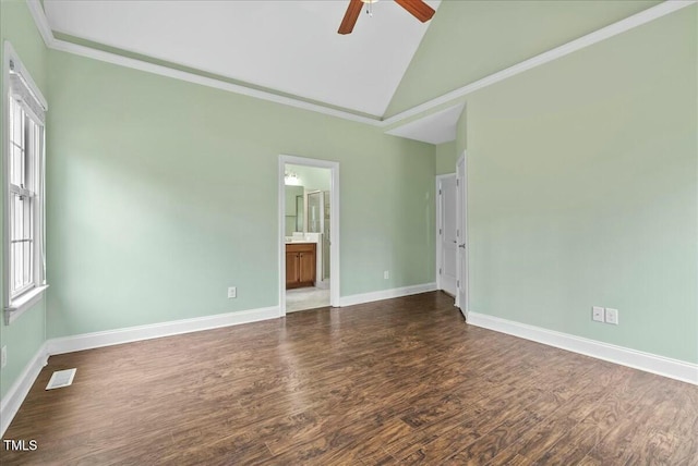 spare room with ceiling fan, dark wood-type flooring, a wealth of natural light, and lofted ceiling