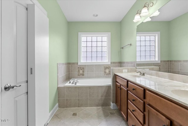 bathroom featuring a relaxing tiled tub, tile patterned floors, and vanity