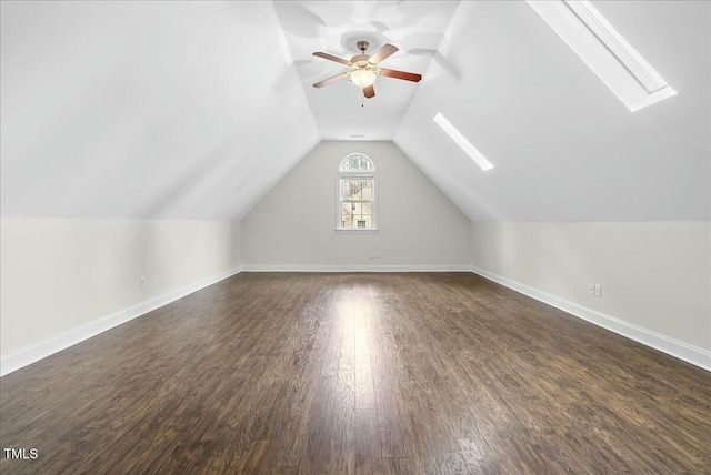 additional living space featuring ceiling fan, dark hardwood / wood-style flooring, and vaulted ceiling with skylight