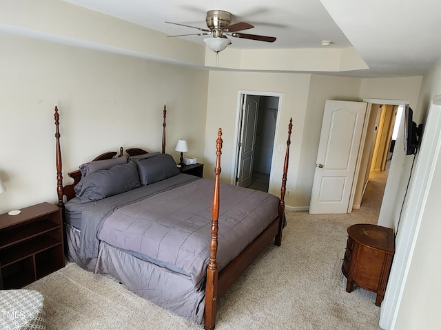 carpeted bedroom with ceiling fan, a walk in closet, and a closet