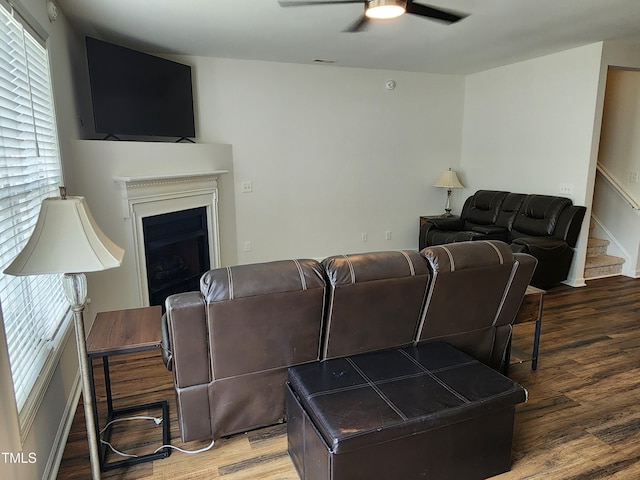 living room with dark hardwood / wood-style flooring and ceiling fan