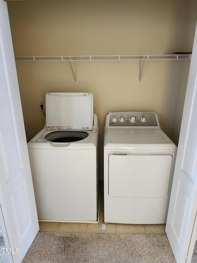 laundry room with washer and dryer and light tile patterned floors