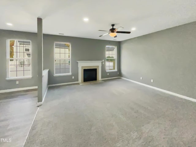 unfurnished living room featuring ceiling fan and a healthy amount of sunlight