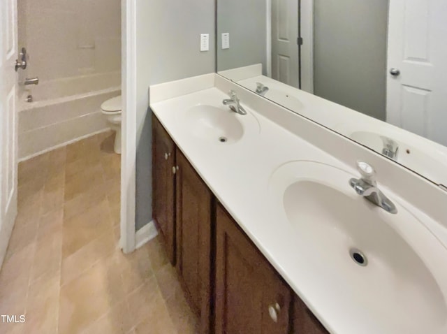 bathroom with tile patterned flooring, vanity, and toilet