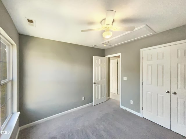 unfurnished bedroom with carpet, a closet, and ceiling fan