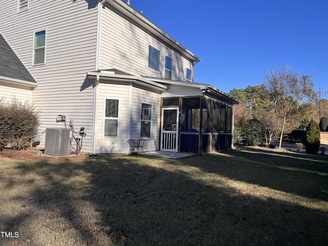 rear view of property with central AC, a sunroom, and a yard