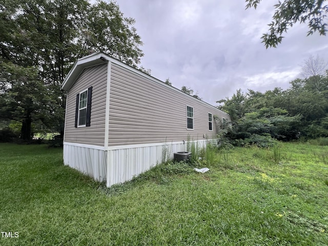 view of property exterior featuring central air condition unit and a yard